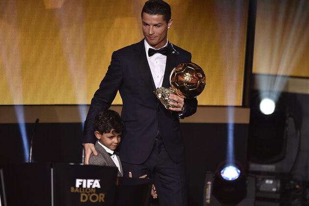 Real Madrid and Portugal forward Cristiano Ronaldo (R) stands on stage with his son Cristiano Jr after receiving the 2014 FIFA Ballon d'Or award ceremony at the Kongresshaus in Zurich on January 12, 2015.    AFP PHOTO / FABRICE COFFRINI        (Photo credit should read FABRICE COFFRINI/AFP/Getty Images)