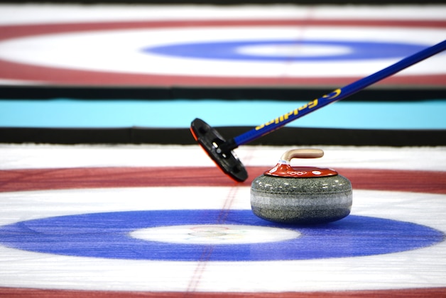 Feb 21, 2014; Sochi, RUSSIA; A detailed view of a stone and sweeper in the curling men's bronze medal match during the Sochi 2014 Olympic Winter Games at Ice Cube Curling Center. Mandatory Credit: James Lang-USA TODAY Sports