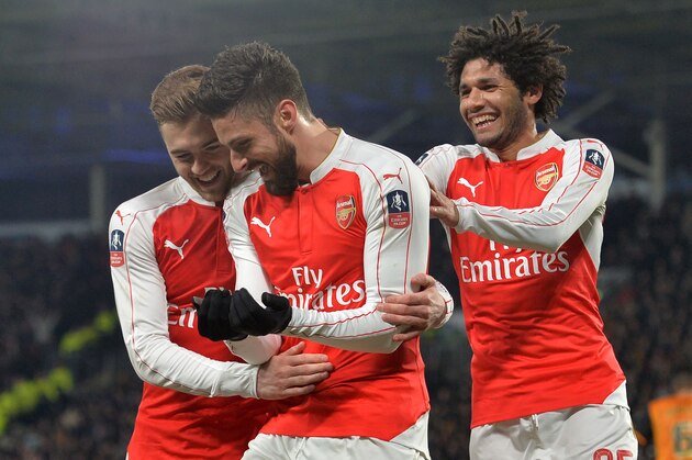 Arsenal's French striker Olivier Giroud (C) celebrates with Arsenal's English defender Calum Chambers (L) and Arsenal's Egyptian midfielder Mohamed Elneny after scoring the opening goal of the English FA cup fifth round replay football match between Hull City and Arsenal at the KC Stadium in Kingston upon Hull in north east England on March 8, 2016.  / AFP / Paul ELLIS / RESTRICTED TO EDITORIAL USE. No use with unauthorized audio, video, data, fixture lists, club/league logos or 'live' services. Online in-match use limited to 75 images, no video emulation. No use in betting, games or single club/league/player publications.  /         (Photo credit should read PAUL ELLIS/AFP/Getty Images)