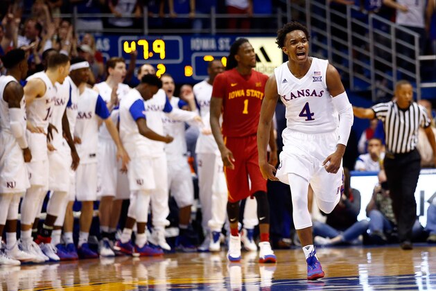 LAWRENCE, KS - MARCH 05:  Devonte' Graham #4 of the Kansas Jayhawks reacts after making a three-pointer as Jameel McKay #1 of the Iowa State Cyclones looks on during the 2nd half of the game at Allen Fieldhouse on March 5, 2016 in Lawrence, Kansas.  (Photo by Jamie Squire/Getty Images)