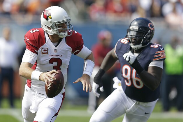 Arizona Cardinals quarterback Carson Palmer (3) scrambles away from Chicago Bears defensive tackle Jarvis Jenkins (96) during the first half of an NFL football game, Sunday, Sept. 20, 2015, in Chicago. (AP Photo/Michael Conroy)
