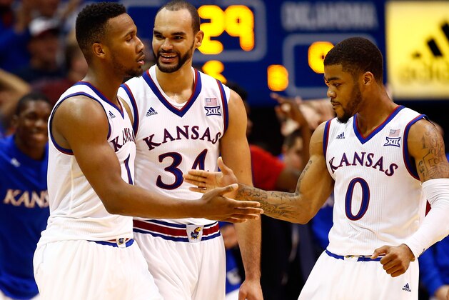 LAWRENCE, KS - JANUARY 04:  Wayne Selden Jr. #1 of the Kansas Jayhawks is congratulated by Perry Ellis #34 and Frank Mason III #0 after making a three-pointer and drawing a foul during the second overtime of the game against the Oklahoma Sooners game at Allen Fieldhouse on January 4, 2016 in Lawrence, Kansas.  The Jayhawks defeated the Sooners in triple overtime with a final score of 109-106 to win the game.  (Photo by Jamie Squire/Getty Images)