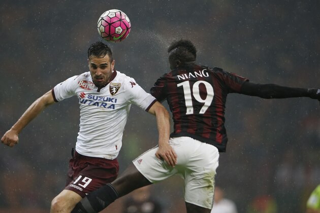 Torino’s Nikola Maksimovic, left, and AC MIlan's M'Baye Niang jump for the ball during a Serie A soccer match between AC Milan and Torino, at the San Siro stadium in Milan, Italy, Saturday, Feb. 27, 2016. (AP Photo/Luca Bruno)