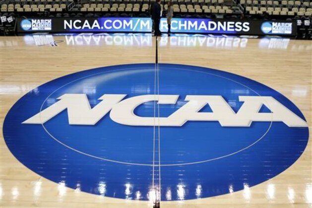 FILE - In this March 18, 2015, file photo, the NCAA logo is at center court as work continues at The Consol Energy Center in Pittsburgh, for the NCAA college basketball second and third round games. A federal judge in Chicago gave preliminary approval Tuesday, Jan. 26, 2016, to a reworked head-injury settlement between thousands of former college athletes and the NCAA that includes a $70 million fund to test for brain trauma. (AP Photo/Keith Srakocic, File)