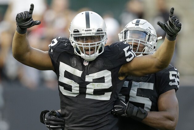 FILE - In this Sunday, Dec. 7, 2014,  file photo, Oakland Raiders outside linebacker Khalil Mack (52) celebrates after sacking San Francisco 49ers quarterback Colin Kaepernick with outside linebacker Sio Moore during the fourth quarter of an NFL football game in Oakland, Calif. The arrival of coach Jack Del Rio's new staff, upgrades made through free agency and a foundation led by last year's top two draft picks, quarterback Derek Carr and linebacker Khalil Mack, have given the Raiders more reasons for optimism that usual heading into training camp (AP Photo/Ben Margot, File)
