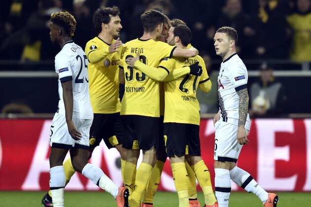 Tottenham’s Joshua Onomah, left, and Kieran Trippier, right, walk on the pitch as Dortmund's players celebrate the opening goal during the Europa League round of 16 first leg soccer match between Borussia Dortmund and Tottenham Hotspur in Dortmund, Germany, Thursday, March 10, 2016. (AP Photo/Martin Meissner)