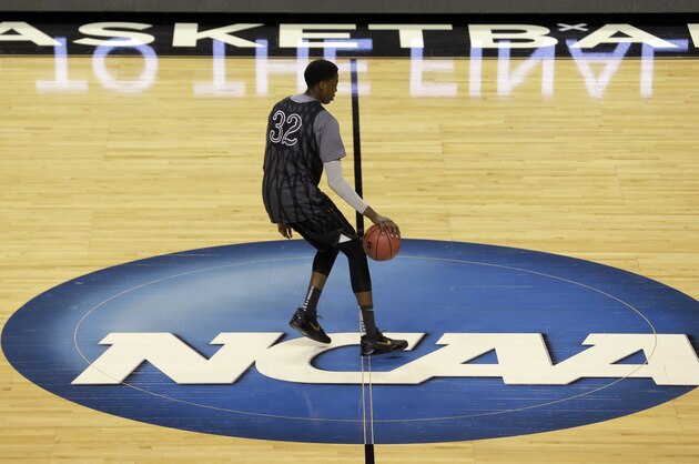Wyoming's Alan Herndon chases an errant ball across the NCAA logo during practice at the NCAA college basketball tournament in Seattle, Thursday, March 19, 2015. Wyoming plays Northern Iowa in the second round on Friday. (AP Photo/Elaine Thompson)