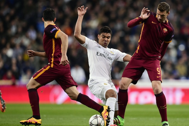 Roma's forward from Bosnia-Herzegovina Edin Dzeko (L) vies with Real Madrid's Brazilian midfielder Casemiro during the UEFA Champions League round of 16, second leg football match Real Madrid FC vs AS Roma at the Santiago Bernabeu stadium in Madrid on March 8, 2016. / AFP / JAVIER SORIANO        (Photo credit should read JAVIER SORIANO/AFP/Getty Images)