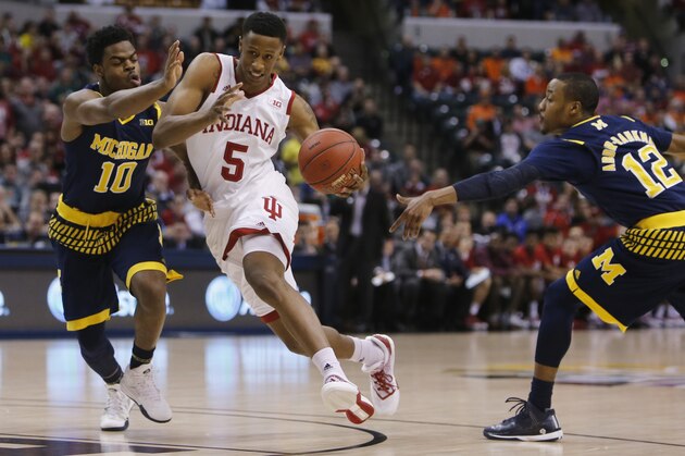 Indiana's Troy Williams (5) drives between Michigan's Derrick Walton Jr. (10) and Muhammad-Ali Abdur-Rahkman (12) in the first half of an NCAA college basketball game in the quarterfinals at the Big Ten Conference tournament, Friday, March 11, 2016, in Indianapolis. (AP Photo/Kiichiro Sato)