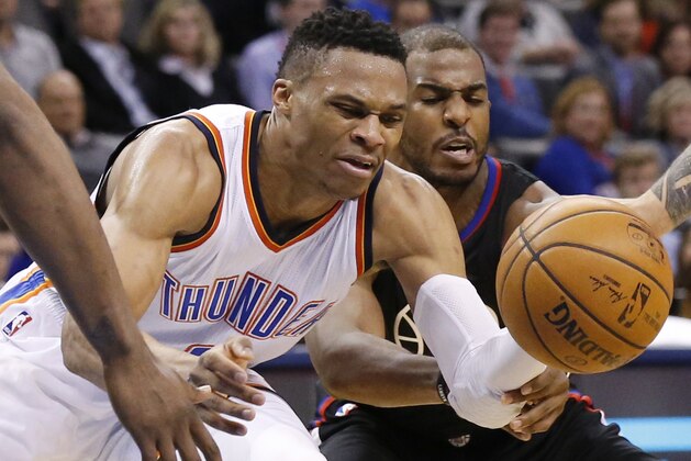 Los Angeles Clippers guard Chris Paul, right, reaches in to try and knock the ball away from Oklahoma City Thunder guard Russell Westbrook, left, during the fourth quarter of an NBA basketball game in Oklahoma City, Wednesday, March 9, 2016. Oklahoma City won 120-108. (AP Photo/Sue Ogrocki)