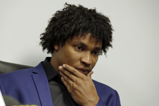 Former New York Mets pitcher Jenrry Mejia, right, listens to questions during a news conference at the office of his attorney in the Queens borough of New York, Friday, March 11, 2016.  Suspended for life by Major League Baseball following his third positive drug test, Mejia spoke about his next step. (AP Photo/Richard Drew)