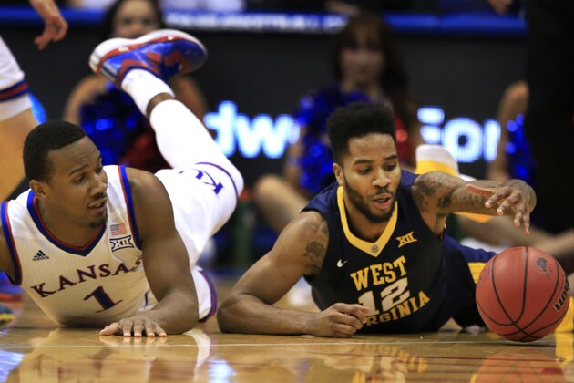 West Virginia guard Tarik Phillip (12) and Kansas guard Wayne Selden Jr. (1) go to the floor during the first half of an NCAA college basketball game in Lawrence, Kan., Tuesday, Feb. 9, 2016. (AP Photo/Orlin Wagner)