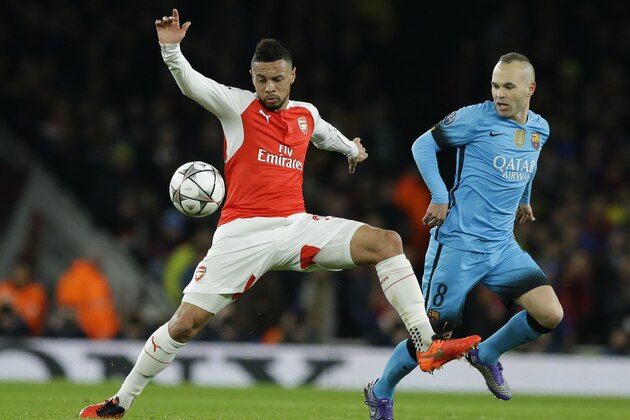 Arsenal's Alex Oxlade-Chamberlain, left, controls the ball as Barcelona's Andres Iniesta looks on during the Champions League round of 16 first leg soccer match between Arsenal and Barcelona at the Emirates stadium London, Tuesday, Feb. 23, 2016. (AP Photo/Matt Dunham)