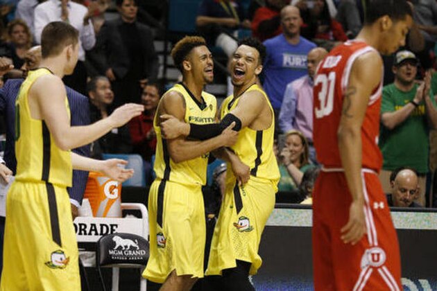 Oregon guard Tyler Dorsey, center left, embraces forward Dillon Brooks as they celebrate after Oregon defeated Utah in an NCAA college basketball game in the championship of the Pac-12 men's tournament Saturday, March 12, 2016, in Las Vegas. Oregon won 88-57. (AP Photo/John Locher)