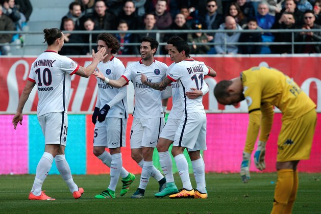 PSG's Javier Pastore, center, celebrates with teammate after scoring, as Troyes' goalkeeper Matthieu Dreyer, right, reacts, during their League One soccer match between Paris Saint Germain and Troyes, in Troyes, France, Sunday, March 13, 2016. (AP Photo/Thibault Camus)