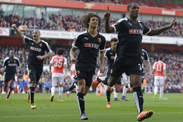 Watford's Odion Ighalo, right, celebrates scoring his side's first goal with Nathan Ake, center, and Adlene Guedioura, left, during the English FA Cup quarterfinal soccer match between Arsenal and Watford at the Emirates stadium in London, Sunday, March 13, 2016.  (AP Photo/Matt Dunham)