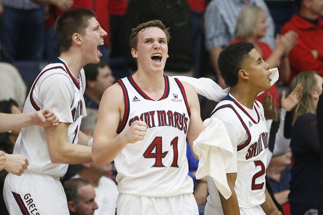 St. Mary's Dane Pineau, left, Emmett Naar (41) and Treaven Duffy, right, celebrates a teammate's basket against BYU in the second half during an NCAA college basketball game in Moraga, Calif., on Saturday, Jan. 17, 2015. St. Mary's won 82-77. (AP Photo/Tony Avelar)