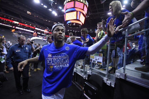 KANSAS CITY, MO - MARCH 12:   Frank Mason III #0 of the Kansas Jayhawks slaps fans hands as he heads to the locker room after Kansas won the Big 12 Basketball Tournament against the West Virginia Mountaineers at Sprint Center on March 12, 2016 in Kansas City, Missouri. (Photo by Ed Zurga/Getty Images)