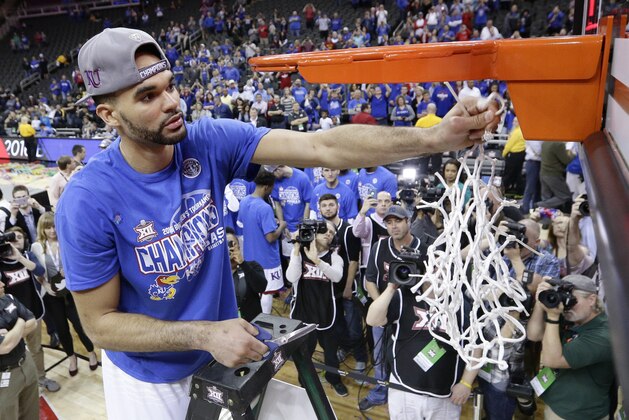 Kansas' Perry Ellis cuts a piece of the net after winning an NCAA college basketball game against West Virginia to win the Big 12 conference tournament Saturday, March 12, 2016, in Kansas City, Mo. (AP Photo/Charlie Riedel)