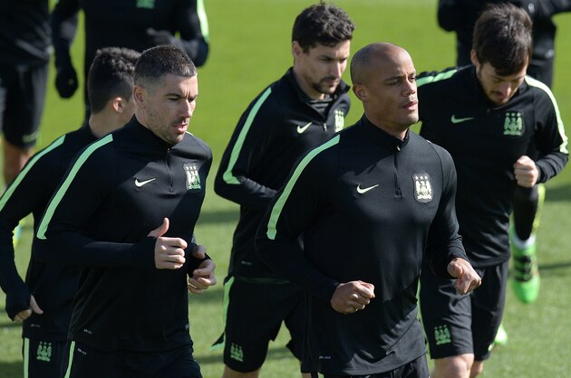 Manchester City's Serbian defender Aleksandar Kolarov (2L) and Manchester City's Belgian defender Vincent Kompany (2R) warm up with teammates during a team training session at the City Football Academy in Manchester, north west England, on March 14, 2016.City play Dynamo Kiev in a Champions League last 16, second leg football match at the Etihad Stadium on March 15. / AFP / OLI SCARFF        (Photo credit should read OLI SCARFF/AFP/Getty Images)