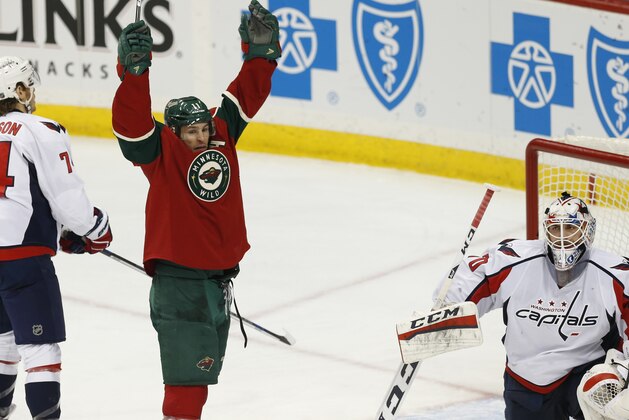 Minnesota Wild’s Zach Parise, left, celebrates a power play goal by Ryan Suter against Washington Capitals goalie Braden Holtby, right,  in the third period of an NHL hockey game, Thursday, Feb. 11, 2016, in St. Paul, Minn. The Capitals won 4-3. (AP Photo/Jim Mone)