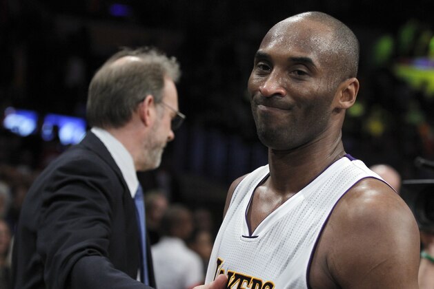 Los Angeles Lakers forward Kobe Bryant, says farewell to New York Knicks head coach Kurt Rambis, left, after the second half of an NBA basketball game in Los Angeles, Sunday, March 13, 2016. The Knicks won 90-87. (AP Photo/Alex Gallardo)