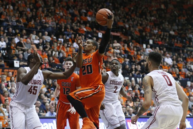 Oregon State's Gary Payton II, center, drives to the basket past Washington State's Valentine Izundu, left, Ike Iroegbu, center rear, and Derrien King, right, in the second half of an NCAA college basketball game in Corvallis, Ore., on Sunday, Feb. 28, 2016. Oregon State won 69-49. (AP Photo/Timothy J. Gonzalez)