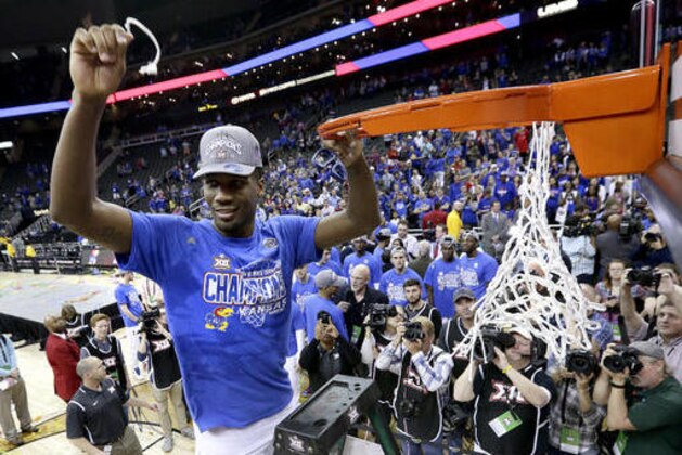 Kansas' Wayne Selden Jr. cuts a piece of the net after winning an NCAA college basketball game against West Virginia to win the Big 12 conference tournament Saturday, March 12, 2016, in Kansas City, Mo. (AP Photo/Charlie Riedel)