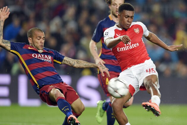 Arsenal's Nigerian forward Alex Iwobi (R) vies with Barcelona's Brazilian defender Dani Alves (L) during the UEFA Champions League Round of 16 second leg football match FC Barcelona vs Arsenal FC at the Camp Nou stadium in Barcelona on March 16, 2016.  / AFP / LLUIS GENE        (Photo credit should read LLUIS GENE/AFP/Getty Images)