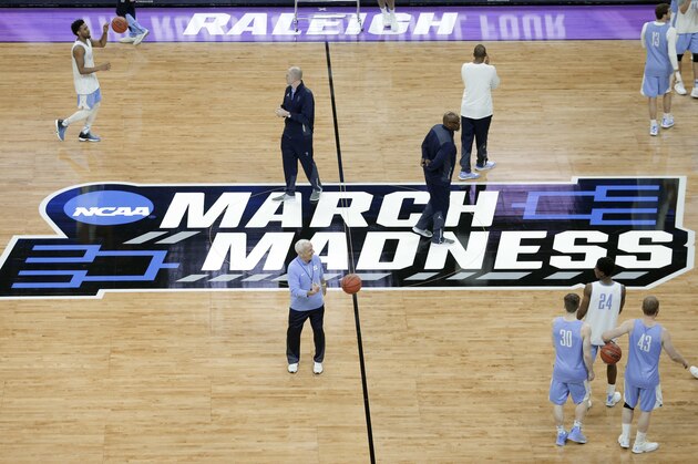 North Carolina head coach Roy Williams, center, passes a ball to players during practice for a first-round men's college basketball game in the NCAA Tournament in Raleigh, N.C., Wednesday, March 16, 2016. North Carolina plays Florida Gulf Coast on Thursday. (AP Photo/Chuck Burton)