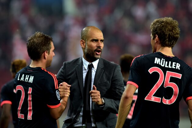Bayern Munich's Spanish coach Josep Guardiola (C) speaks with Bayern Munich's German forward Thomas Mueller (R) after his team won against Olympiakos during the Group F Champions League football match at the Karaiskaki stadium in Athens on September 16, 2015. AFP PHOTO / ARIS MESSINIS        (Photo credit should read ARIS MESSINIS/AFP/Getty Images)