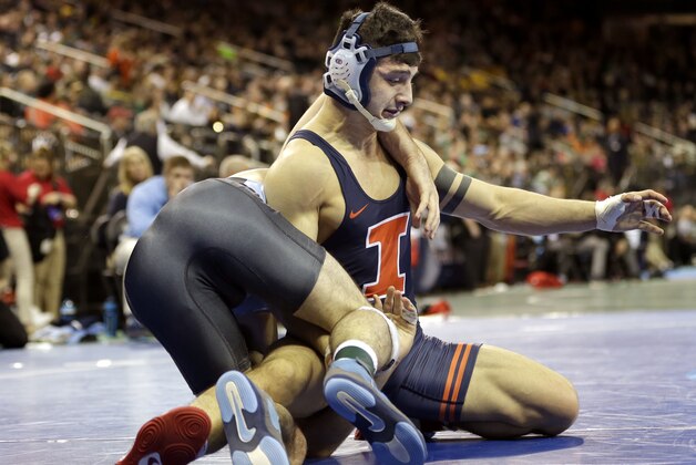 Illinois' Isaiah Martinez, top, battles with University of North Carolina's Robert Henderson in a 157-pound match during the NCAA Division 1 wrestling championship in New York, Thursday, March 17, 2016. (AP Photo/Seth Wenig)