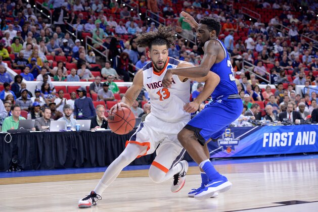RALEIGH, NORTH CAROLINA - MARCH 17:  Anthony Gill #13 of the Virginia Cavaliers drives on Dionte Adams #32 of the Hampton Pirates in the first half in the first round of the 2016 NCAA Men's Basketball Tournament at PNC Arena on March 17, 2016 in Raleigh, North Carolina.  (Photo by Grant Halverson/Getty Images)