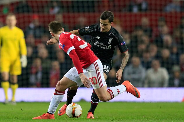 Liverpool’s Philippe Coutinho, right, takes the ball past United’s Guillermo Varela during the Europa League round of 16, second leg, soccer match between  Manchester United and Liverpool at Old Trafford Stadium in Manchester, England, Thursday March 17, 2016. (AP Photo/Jon Super)
