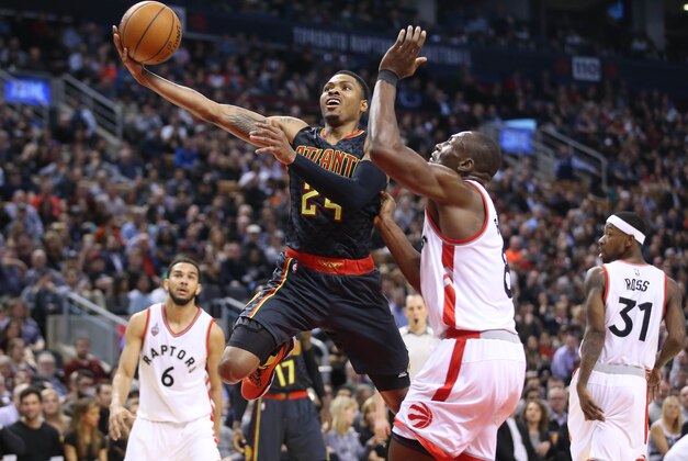 Mar 10, 2016; Toronto, Ontario, CAN; Atlanta Hawks guard Kent Bazemore (24) is fouled by Toronto Raptors center Bismack Biyombo (8) at Air Canada Centre. The Raptors beat the Hawks 104-96. Mandatory Credit: Tom Szczerbowski-USA TODAY Sports