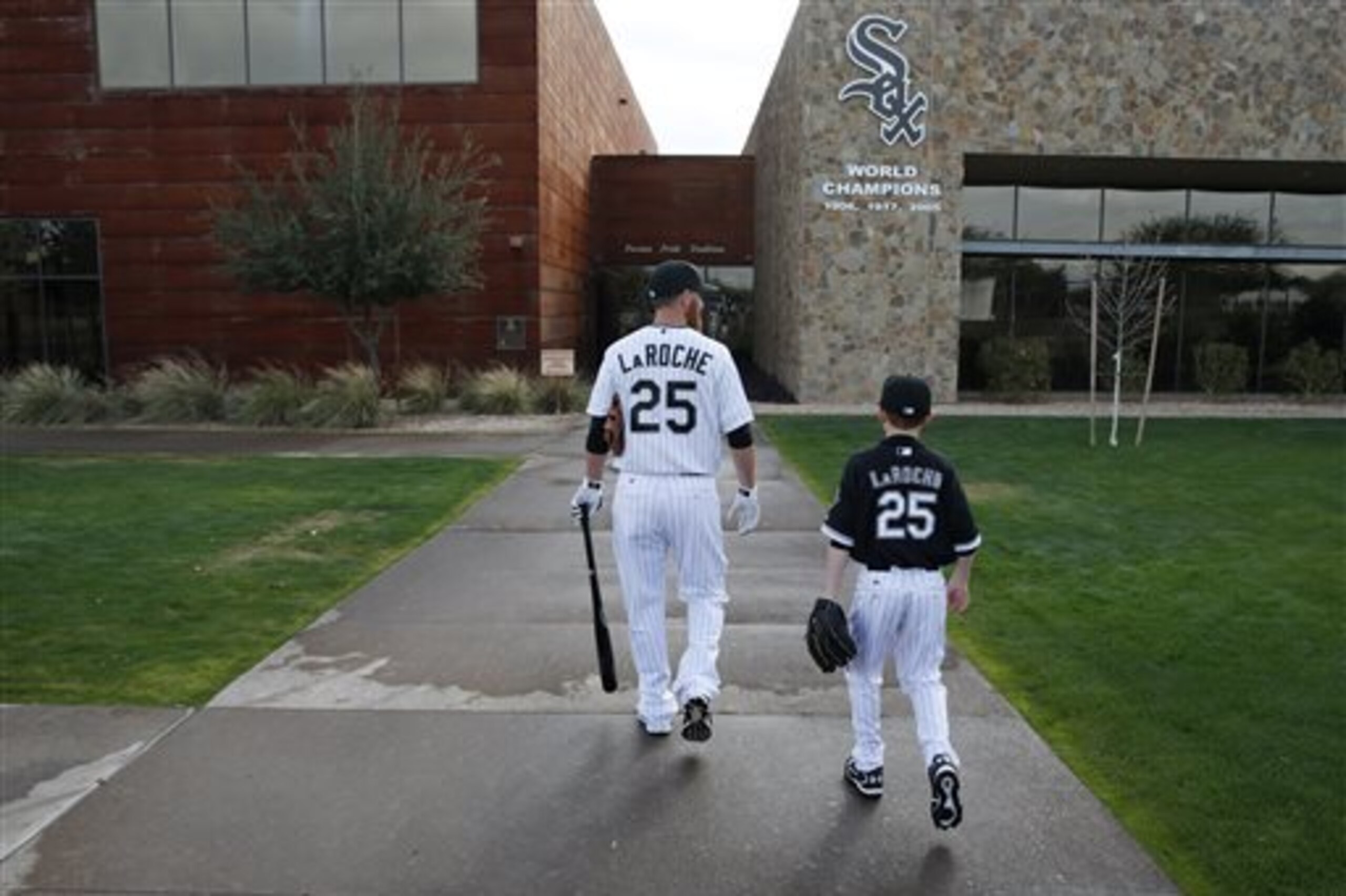 FILE - In this Feb. 28, 2015, file photo, Chicago White Sox's Adam LaRoche, left, and his son Drake walk to the White Sox's clubhouse during a photo day before a baseball spring training workout in Phoenix. Kudos to Adam LaRoche for wanting to spend time with his son, and walking away from a $13 million salary to make sure that happened. But there's nothing wrong with the White Sox telling the now-retired first baseman that
