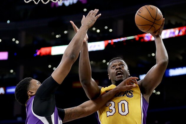 Los Angeles Lakers forward Julius Randle, right, shoots around Sacramento Kings forward Rudy Gay during the second half of an NBA basketball game in Los Angeles, Tuesday, March 15, 2016. (AP Photo/Chris Carlson)