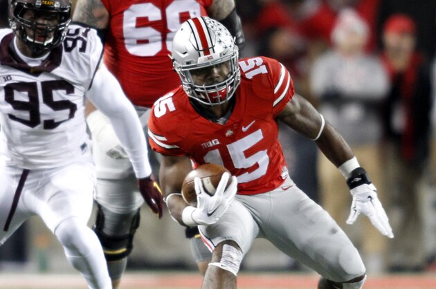 Ohio State running back Ezekiel Elliott, right, gets past Minnesota defender Hendrick Ekpe during an NCAA college football game Saturday, Nov. 7, 2015, in Columbus, Ohio. Ohio State beat Minnesota 28-14. (AP Photo/Paul Vernon)