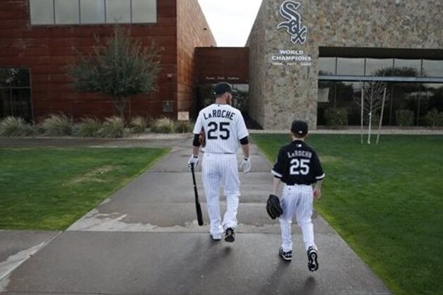 FILE - In this Feb. 28, 2015, file photo, Chicago White Sox's Adam LaRoche, left, and his son Drake walk to the White Sox's clubhouse during a photo day before a baseball spring training workout in Phoenix. Kudos to Adam LaRoche for wanting to spend time with his son, and walking away from a $13 million salary to make sure that happened. But there's nothing wrong with the White Sox telling the now-retired first baseman that