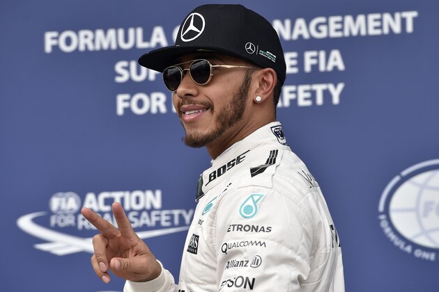Mercedes AMG Petronas F1 Team's British driver Lewis Hamilton flashes the victory sign after taking pole position in the qualifying session of the Formula One Australian Grand Prix in Melbourne on March 19, 2016. / AFP / SAEED KHAN        (Photo credit should read SAEED KHAN/AFP/Getty Images)