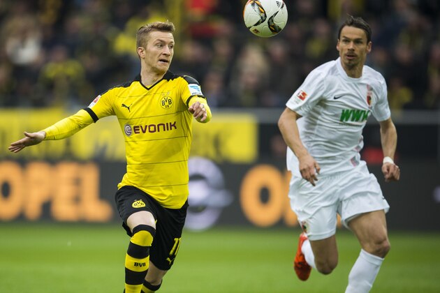 Dortmund's forward Marco Reus (L) and Augsburg's midfielder Markus Feulner vie for the ball during the German first division football Bundesliga match between Borussia Dortmund and FC Augsburg on October 25, 2015 in Dortmund, western Germany. Dortmund wom the match 5-1. AFP PHOTO / ODD ANDERSEN        (Photo credit should read ODD ANDERSEN/AFP/Getty Images)