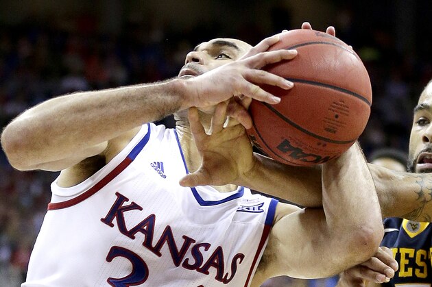 West Virginia's Jaysean Paige (5) tries to steal the ball from Kansas' Perry Ellis during the second half of an NCAA college basketball game in the finals of the Big 12 conference tournament Saturday, March 12, 2016, in Kansas City, Mo. (AP Photo/Charlie Riedel)