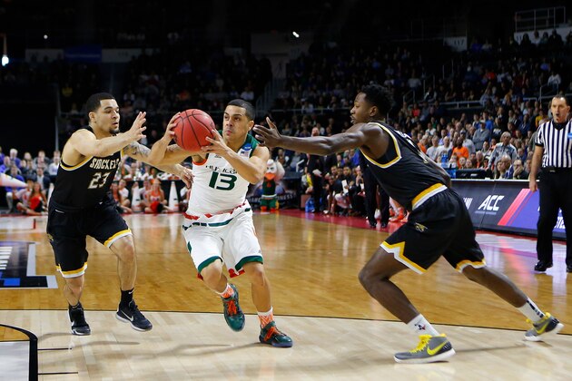Mar 19, 2016; Providence, RI, USA; Miami (Fl) Hurricanes guard Angel Rodriguez (13) drives past Wichita State Shockers guard Fred VanVleet (23) and Shockers forward Zach Brown (1) during the first half of a second round game of the 2016 NCAA Tournament at Dunkin Donuts Center. Mandatory Credit: Winslow Townson-USA TODAY Sports
