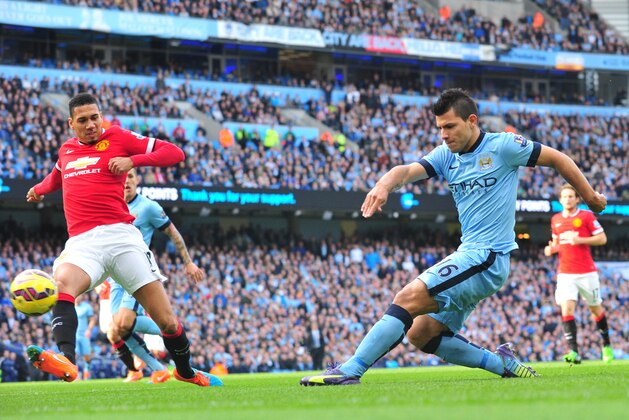 Manchester United's English defender Chris Smalling (L) tries to defend against Manchester City's Argentinian striker Sergio Aguero (R) during the English Premier League football match between Manchester City and Manchester United at the The Etihad Stadium in Manchester, northwest England on November 2, 2014. Manchester City won 1-0.   AFP PHOTO / PAUL ELLIS

RESTRICTED TO EDITORIAL USE. No use with unauthorized audio, video, data, fixture lists, club/league logos or live services. Online in-match use limited to 45 images, no video emulation. No use in betting, games or single club/league/player publications.        (Photo credit should read PAUL ELLIS/AFP/Getty Images)