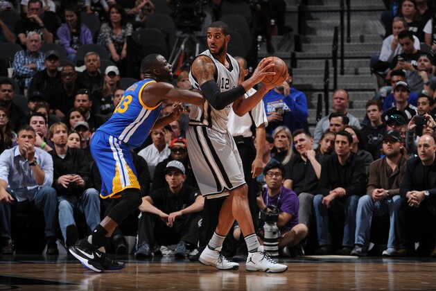 SAN ANTONIO, TX - MARCH 19:  LaMarcus Aldridge #12 of the San Antonio Spurs handles the ball against Draymond Green #23 of the Golden State Warriors on March 19, 2016 at the AT&T Center in San Antonio, Texas. NOTE TO USER: User expressly acknowledges and agrees that, by downloading and or using this photograph, user is consenting to the terms and conditions of the Getty Images License Agreement. Mandatory Copyright Notice: Copyright 2016 NBAE (Photos by Garrett Ellwood/NBAE via Getty Images)