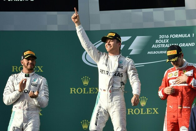Mercedes AMG Petronas F1 Team's German driver Nico Rosberg (C) celebrates his win on the podium as second placed Mercedes AMG Petronas F1 Team's British driver Lewis Hamilton (L) and third placed Ferrari's German driver Sebastian Vettel (R) gesture following the Formula One Australian Grand Prix in Melbourne on March 20, 2016.  / AFP / SAEED KHAN        (Photo credit should read SAEED KHAN/AFP/Getty Images)