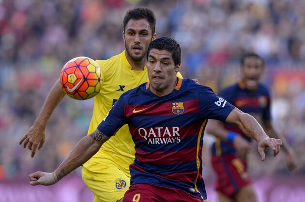 Villarreal's defender Victor Ruiz (L) vies with Barcelona's Uruguayan forward Luis Suarez during the Spanish league football match FC Barcelona vs Villarreal CF at the Camp Nou stadium in Barcelona on November 8, 2015.   AFP PHOTO/ JOSEP LAGO        (Photo credit should read JOSEP LAGO/AFP/Getty Images)
