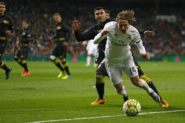 Real Madrid 's Luka Modric, right, is tackled by Sevilla's Jose Antonio Reyes during a Spanish La Liga soccer match between Real Madrid and Sevilla at the Santiago Bernabeu stadium, in Madrid, Sunday, March 20, 2016. Real Madrid defeated Sevilla 4-0.  (AP Photo/Francisco Seco)