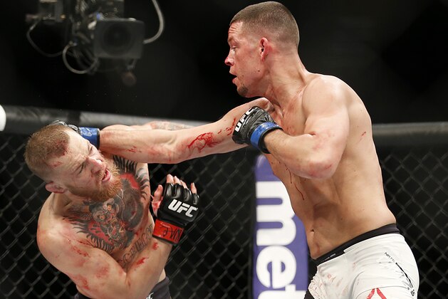 Conor McGregor, left, trades punches with Nate Diaz during their UFC 196 welterweight mixed martial arts match, Saturday, March 5, 2016, in Las Vegas. (AP Photo/Eric Jamison)