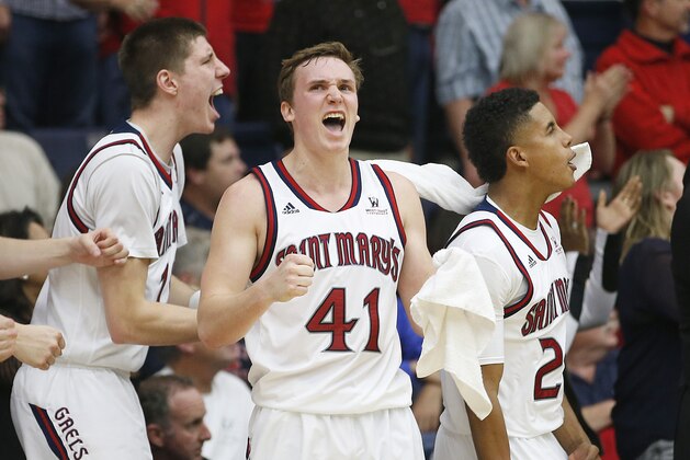St. Mary's Dane Pineau, left, Emmett Naar (41) and Treaven Duffy, right, celebrates a teammate's basket against BYU in the second half during an NCAA college basketball game in Moraga, Calif., on Saturday, Jan. 17, 2015. St. Mary's won 82-77. (AP Photo/Tony Avelar)